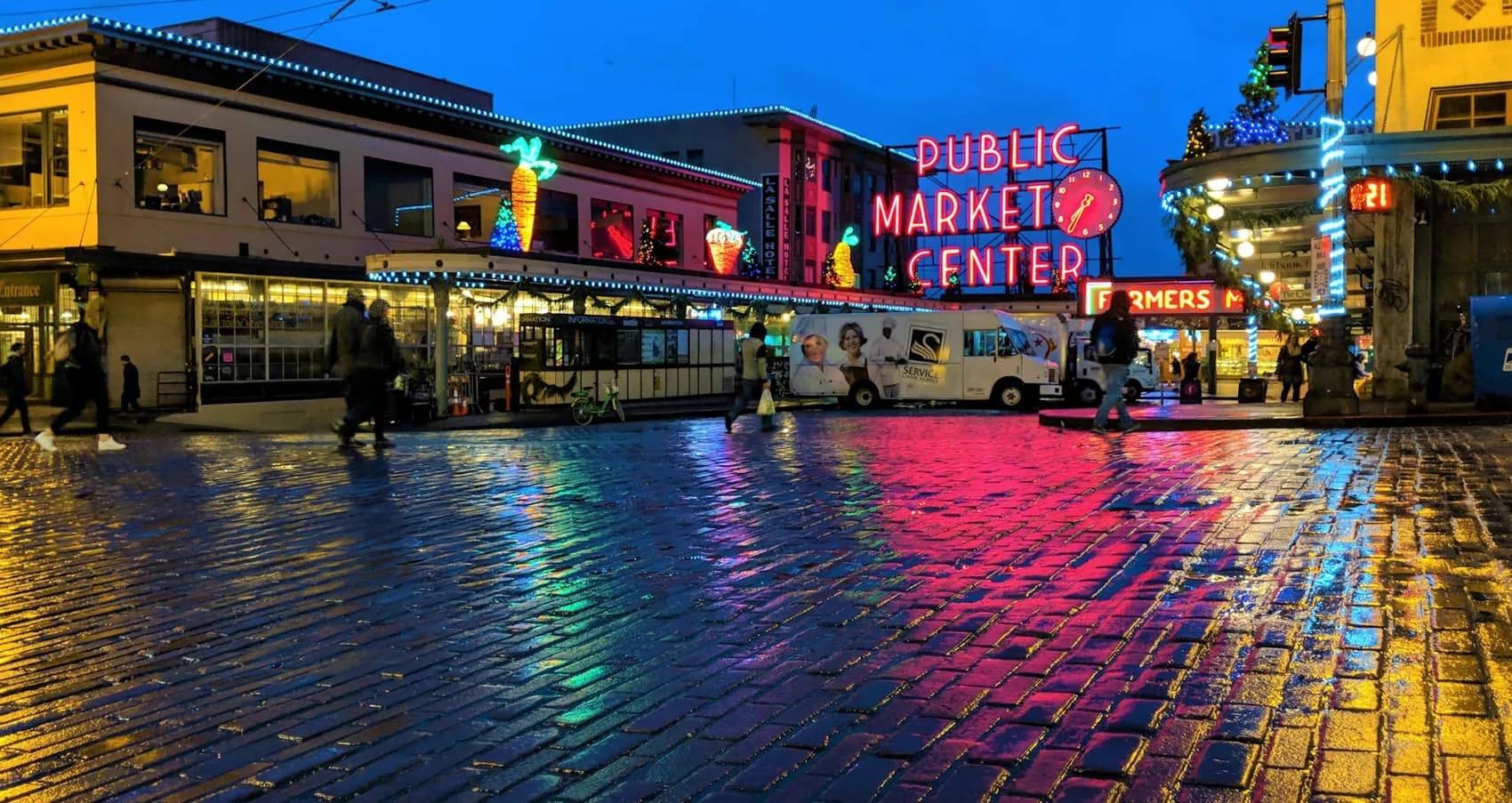 Pike Place Market in Seattle on a wet evening, neon signs reflected in the rain-soaked street